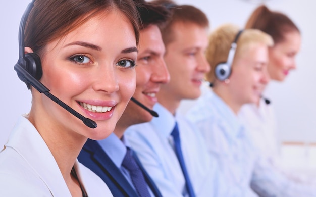 Привлекательные улыбающиеся позитивные молодые бизнесмены и коллеги в офисе call-центра