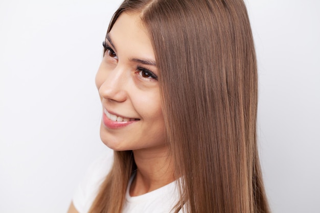 Attractive smiling woman brushing her long straight hair