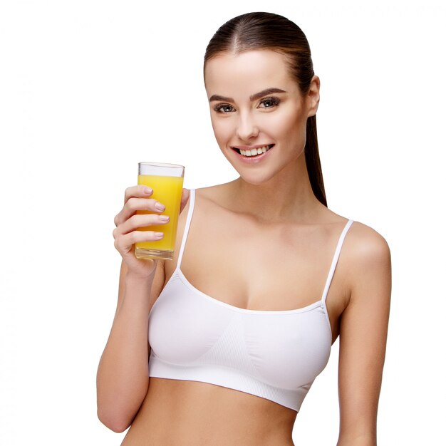 attractive smiling woman holding glass of orange juice on white