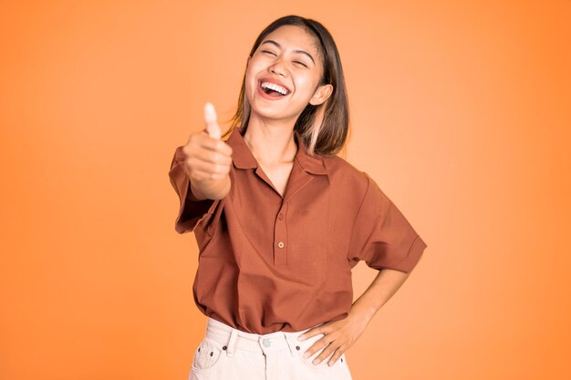 Attractive smiling young woman stand with thumbs up on isolated background person