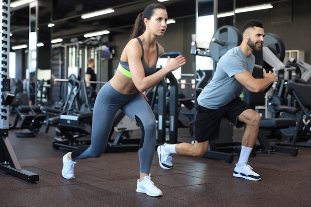 Attractive sport couple doing fitness at gym.