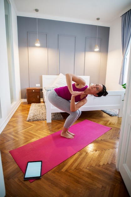 Attractive sporty middle aged woman doing yoga exercise