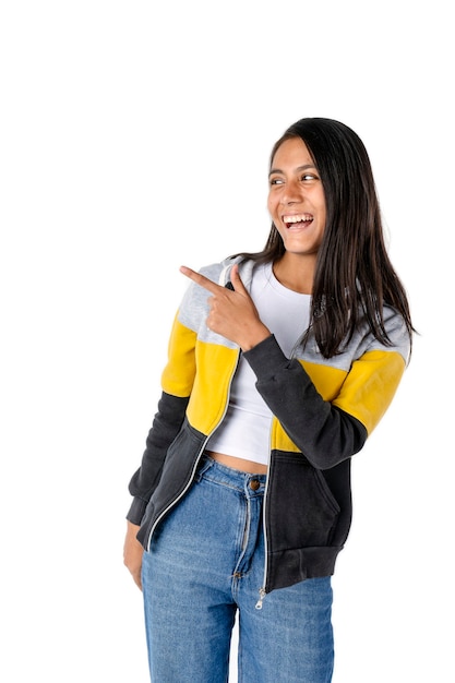 Attractive straight black haired Latina woman pointing to the side with a big smile looking into the same pointed space 