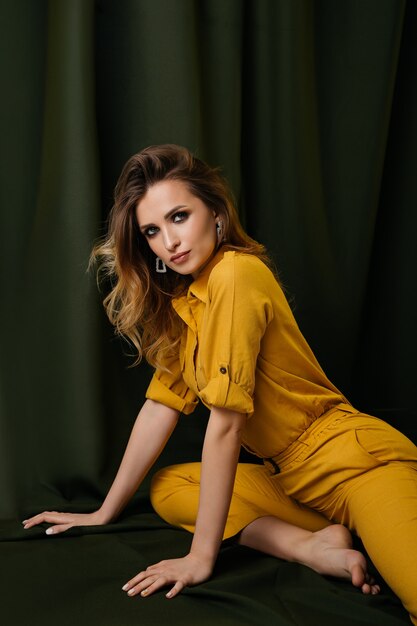 Attractive stylish woman in fashionable yellow clothes posing. Stylish concept