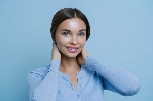 魅力的なスタイリッシュな若い女性モデルは、穏やかで陽気な魅惑的な表情を持っています