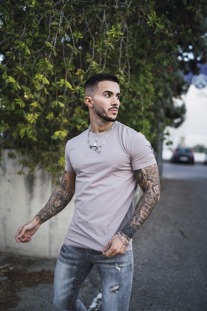 Attractive stylish young man wearing a beige T-shirt and jeans