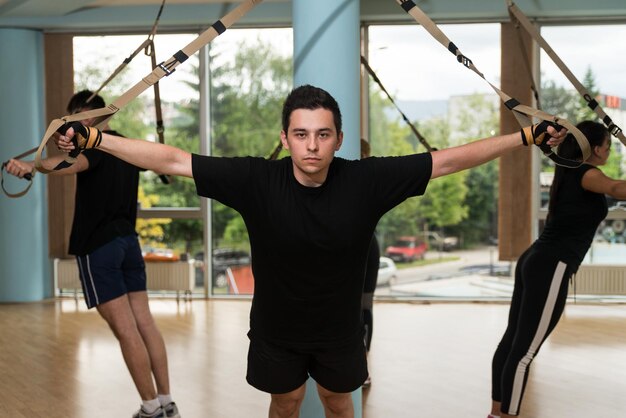 Attractive Team Training With Fitness Trx Straps in the Gym