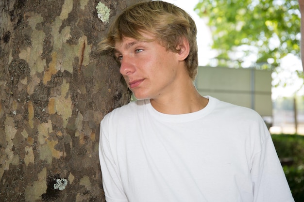 Photo attractive teenage boy in green urban background