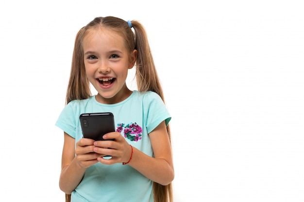Привлекательная девушка подросток в повседневной одежде палочки на смартфоне на белом фоне с копией пространства