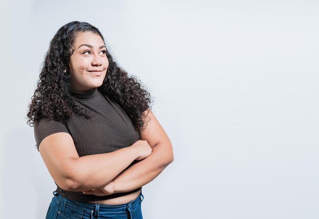 Attractive thoughtful girl with crossed arms isolated Latin girl imagining with crossed arms People thinking things on isolated background