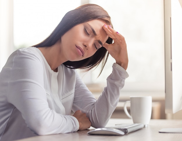 Attractive tired business lady is having a headache.