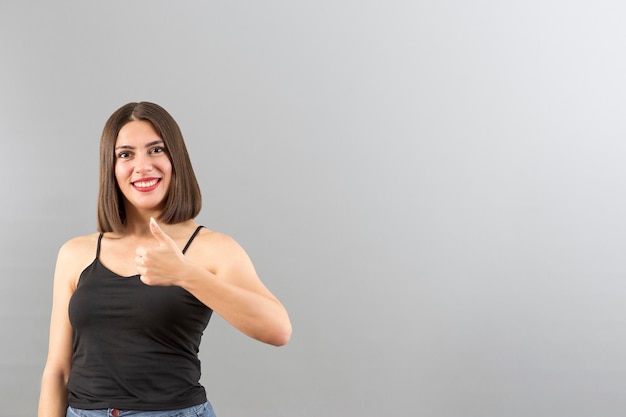 Attractive Turkish woman portrait in positive mood She is gesturing thumbs up