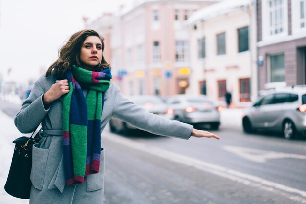 Attractive in winter outfit catching taxi at street