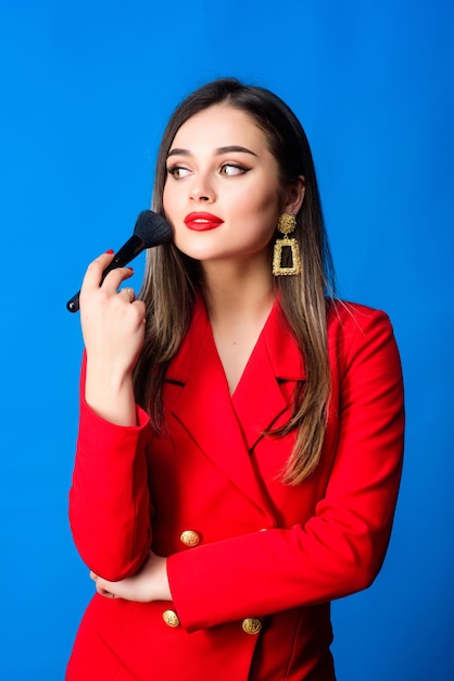 Attractive woman applying makeup brush Hiding all imperfections Perfect skin tone Makeup artist concept Girl apply powder cheeks Looking good and feeling confident Gorgeous lady makeup red lips