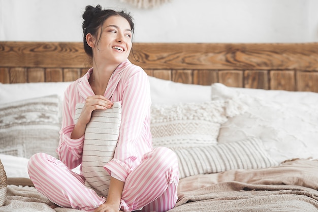 Attractive woman in bedroom. Female in pajamas.