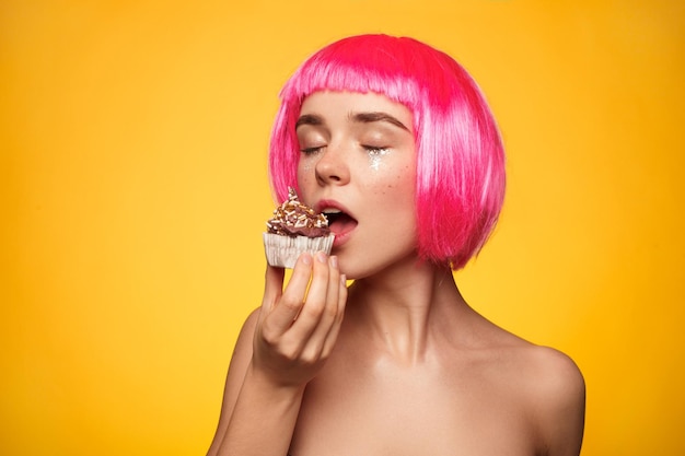 Attractive woman biting cupcake