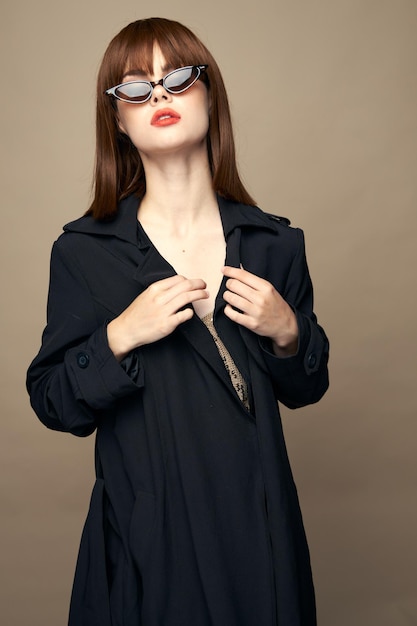 Привлекательная женщина в черном пальто, уверенная в себе, веселая в студии.