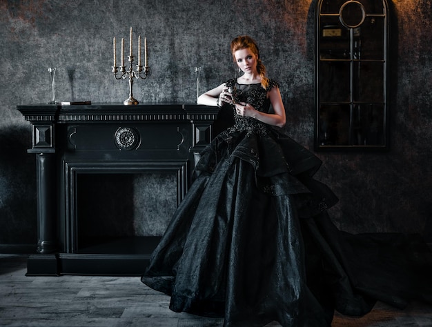 Attractive woman in black dress in medieval interior