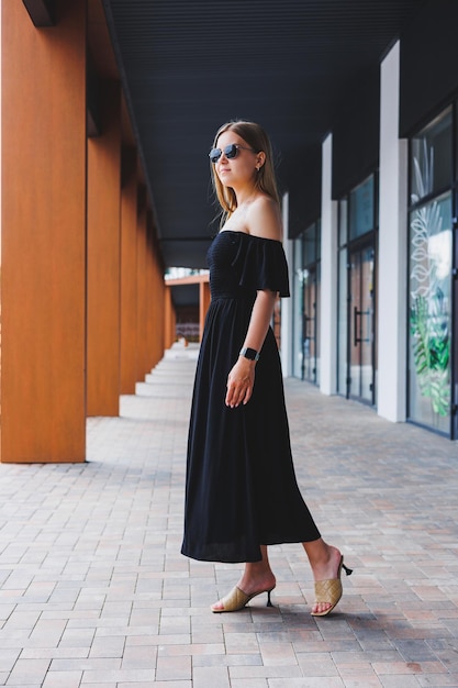 Attractive woman in a black summer dress and heeled sandals Summer women's casual fashion