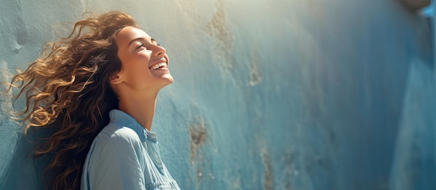 Photo attractive woman on blue city wall with sunshine in summer smiling she gazes towards blank space for text