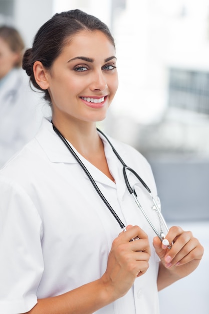 Attractive woman doctor holding her stethoscope at a hospital