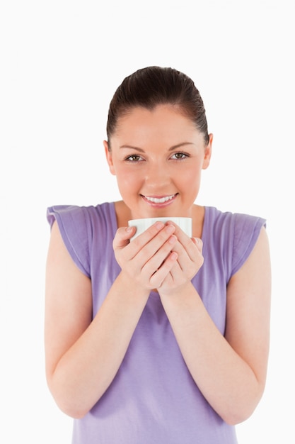 Attractive woman enjoying a cup of coffee while standing