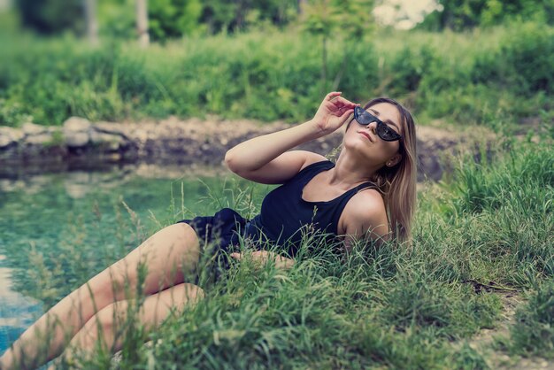 Attractive woman enjoying nature near pound, sunny day