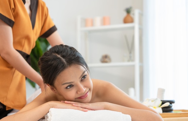 Attractive woman enjoying Thai massage in spa salon