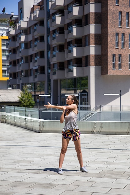 Attractive woman exercise stretching in urban environment at sunny day