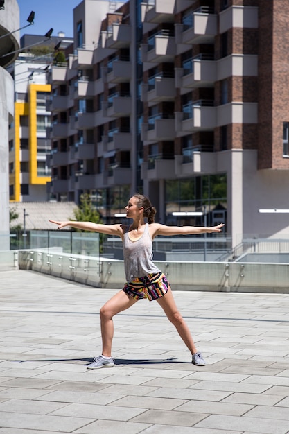 Attractive woman exercise stretching in urban environment at sunny day