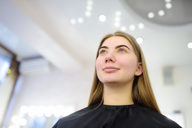 Foto donna attraente che ottiene cura del viso al salone di bellezza. sopracciglia di architettura perfette. cura del viso e trucco.