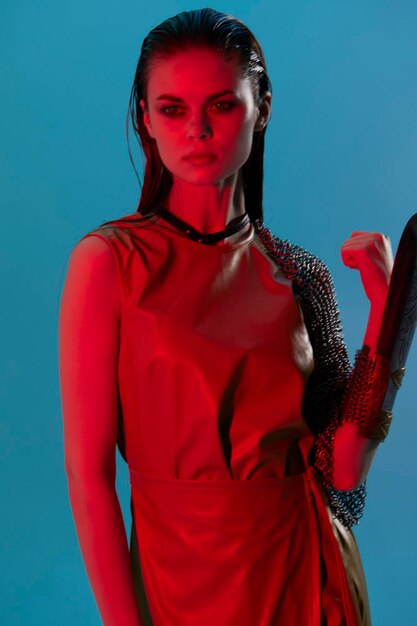 Foto donna attraente glamour che posa un'armatura di metallo chiaro rosso su uno sfondo isolato a mano foto di alta qualità