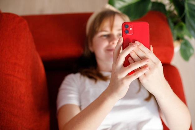 写真 魅力的な女性はソファに横たわって幸せで,携帯電話を使用して,アプリケーションを使用するためにインターネットに接続します.