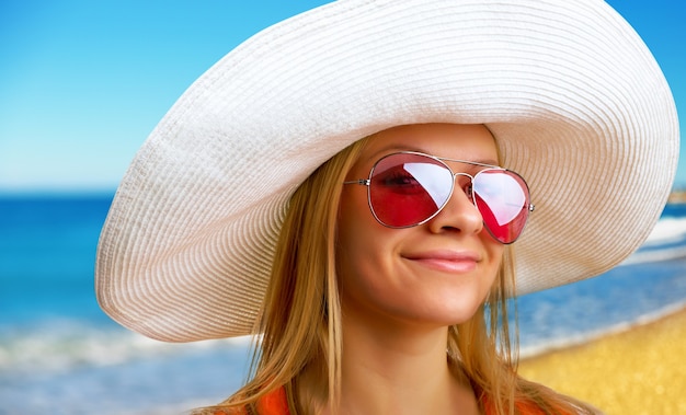 Attractive woman in hat relaxing on the beach