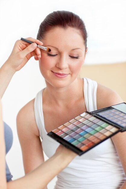 Attractive woman having a make-up lesson at home