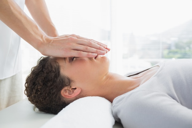 Attractive woman having reiki treatment