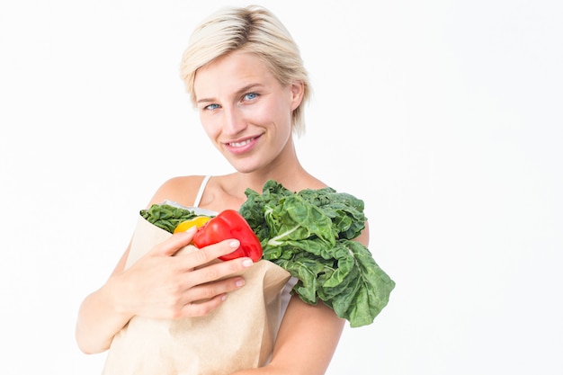 Привлекательная женщина держит мешок с овощами