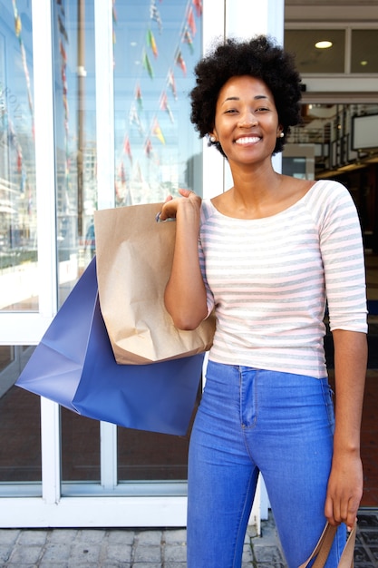 Attractive woman holding bags outside mall