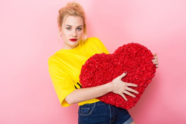 Attractive woman holding big red flower heart