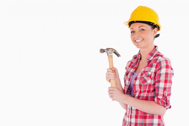 Attractive woman holding a hammer while standing