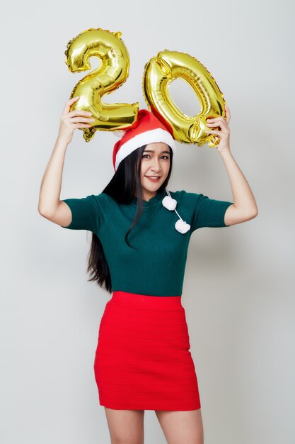 Attractive woman holding metallic foil balloon number