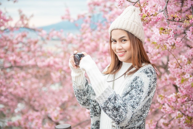 魅力的な女性は日本の松田で桜を楽しんでいます