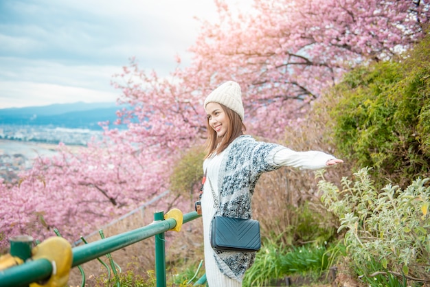 魅力的な女性は公園で桜と楽しんでいます。