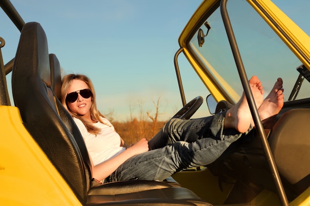 Attractive woman in a jeep in summer