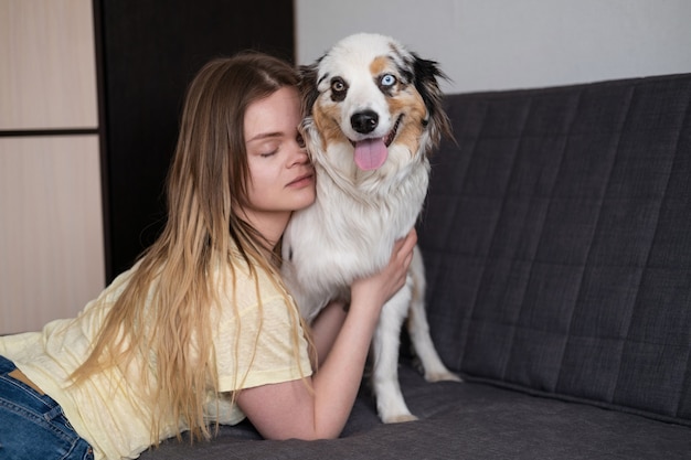 写真 魅力的な女性のキスは青いメルルオーストラリアンシェパード犬を抱きしめます