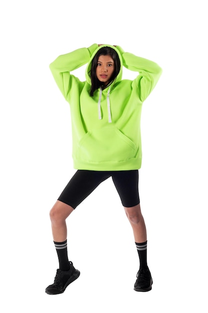 Attractive woman of Latin appearance wears a green hooded hoodie on a white background The girl looks sexy and happy The elegant brunette is wearing a dark sweatshirt Allseason clothing
