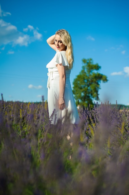 La donna attraente sul campo di lavanda si diverte