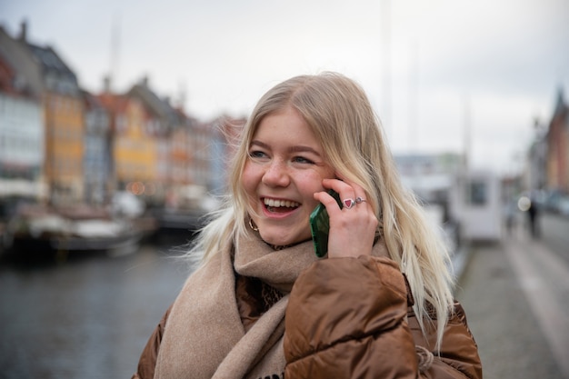 Attractive woman makes phone call with friend and smiles