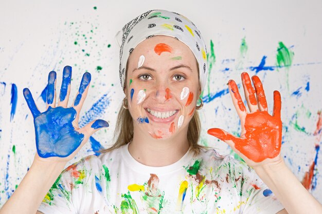 Foto donna attraente che dipinge lo sfondo di molti colori