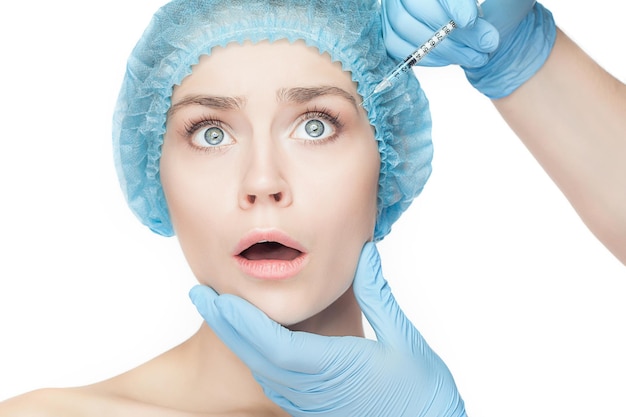 Attractive woman at plastic surgery with syringe in her face